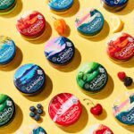 Assorted colorful tins with berries on yellow