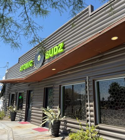 Atomic Budz dispensary storefront under blue sky